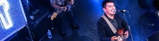 Kesheno Titos cantando con guitarra en un escenario